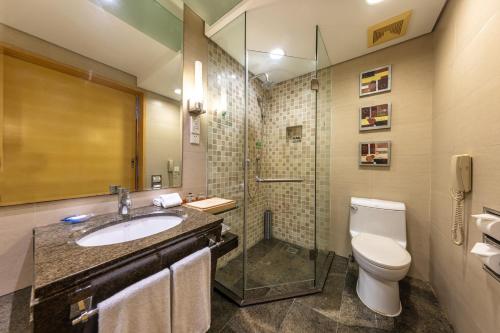 a bathroom with a sink and a toilet and a shower at Weihai Haiyue Jianguo Hotel in Weihai