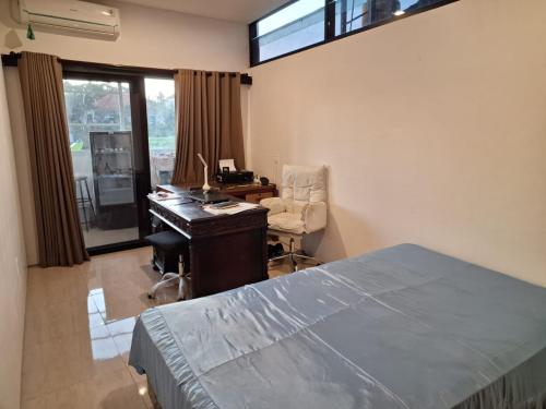 a bedroom with a desk and a bed and a chair at Casa 7 in Dalung