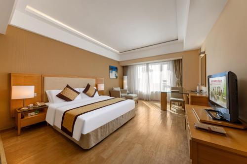 a hotel room with a large bed and a television at Weihai Haiyue Jianguo Hotel in Weihai