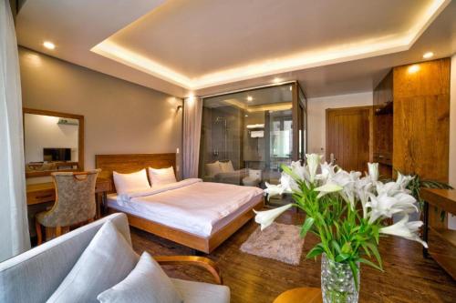 a hotel room with a bed and a vase of flowers at SAPA HUB hostel in Sa Pa