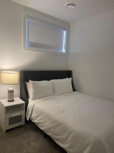 YYCにあるWestminister Manorの窓のある白いベッドのある寝室