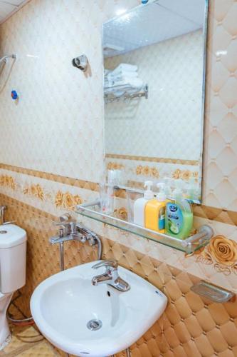 a bathroom with a sink and a mirror and a toilet at SAPA HUB hostel in Sa Pa