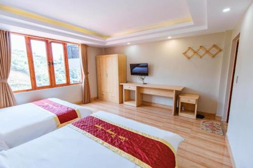a hotel room with two beds and a desk at SAPA HUB hostel in Sa Pa
