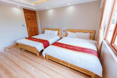 two beds in a small room with wooden floors at SAPA HUB hostel in Sa Pa