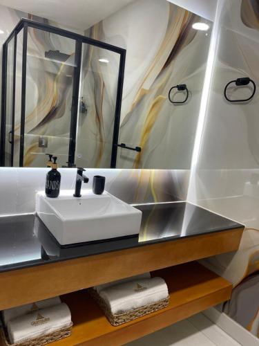 a bathroom with a sink and a mirror and towels at GLAMSUITE Premiun Montañita in Montañita