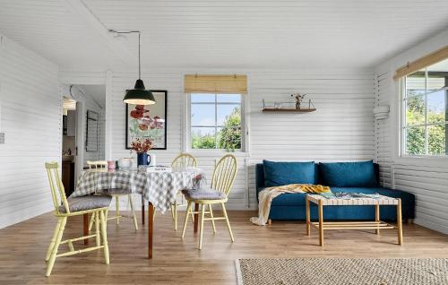 a dining room with a blue couch and a table at Pet Friendly Home In Aabenraa With Wifi - F07406 in Aabenraa