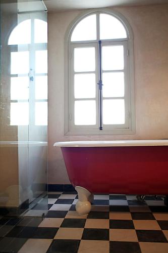 a bathroom with a red tub and a window at L'Alcazar in Rabat