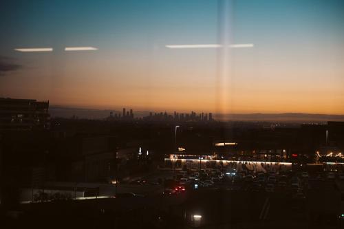 a view of a city at night with the sun setting at Mercure Melbourne Doncaster in Doncaster