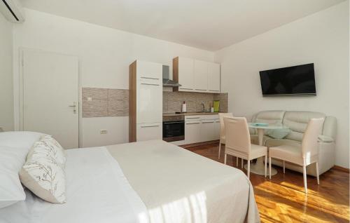 a bedroom with a bed and a table and a kitchen at Nice Apartment In Lovran With Wifi in Lovran
