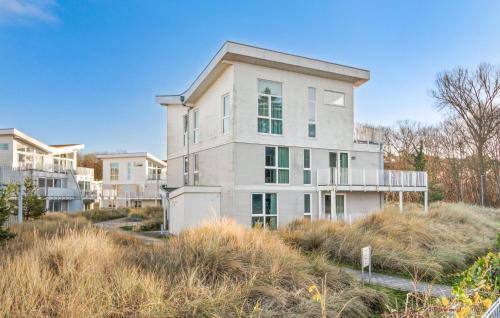 a large white house on a hill with tall grass at Dünenvilla 1, Whg 5 in Travemünde