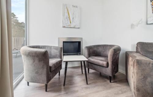 a living room with two chairs and a table and a tv at Dünenvilla 1, Whg 5 in Travemünde