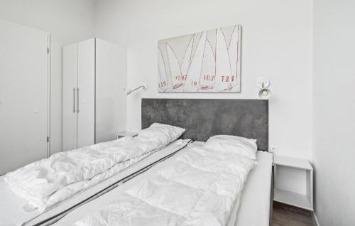a bed with white sheets on it in a room at Dünenvilla 1, Whg 5 in Travemünde