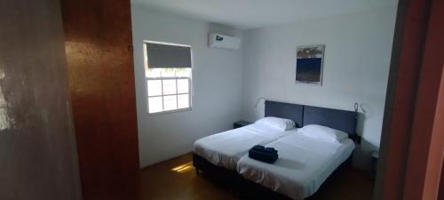 a bedroom with a bed with a black bag on it at The Dive Hut - Boutique Apartments in Kralendijk