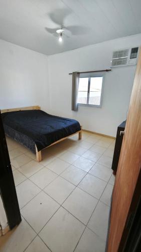 a bedroom with a bed and a tiled floor at Lavalle in Santiago del Estero