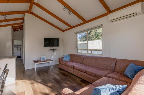 a living room with a couch and a table at Ocean Grove Holiday Park in Ocean Grove