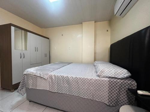 a small bedroom with a bed and a cabinet at Studio no centro de Belém - COP 30 in Belém