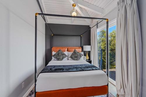 a bedroom with a canopy bed with a window at Lago Luxury Retreat - Sunset Views of Lake Travis in Lago Vista