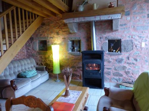 a living room with a couch and a wood stove at Gîte familial avec pêche, cascade, animaux et activités variées, proche de Vichy et Le PAL - FR-1-489-122 in Barrais-Bussolles