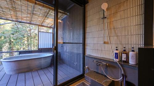 a bathroom with a tub and a window at Kaze no Tani no Iori in Gamagori