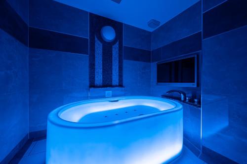 a blue room with a tub in a bathroom at Lucky Sun in Nishinomiya
