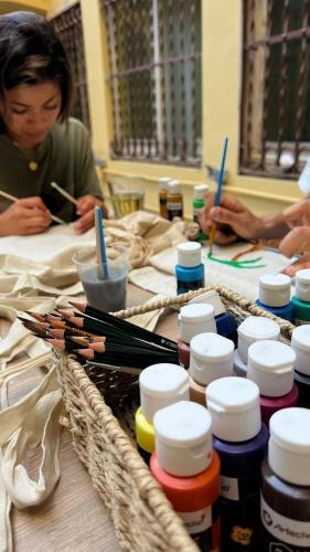 a group of people sitting at a table with paint brushes at The Loft House Barcelona in Barcelona