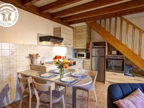 - une cuisine avec une table et des fleurs dans l'établissement Charmant Gîte avec Jardin Privatif, Proche Montbrison, Équipé Moderne et Confort Total - FR-1-496-117, à Pralong