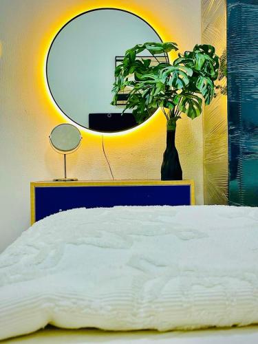 a bedroom with a bed and a mirror and a plant at 1bedroom hall in Ajman 