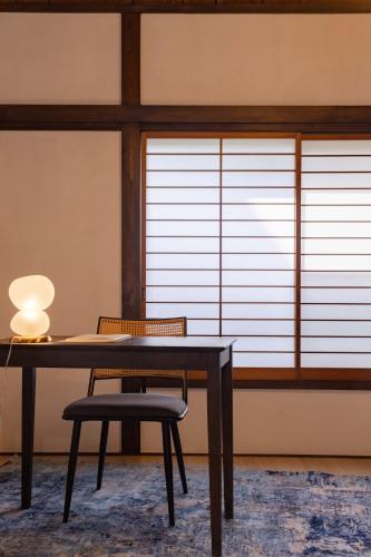 a table and a chair with a lamp and a window at Macchiato SHONAN-Vacation Stay- in Hiratsuka