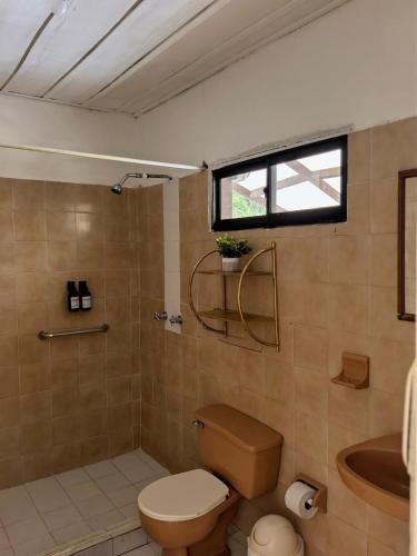 a bathroom with a toilet and a tub and a sink at Nativo Casa Colonial in Salento
