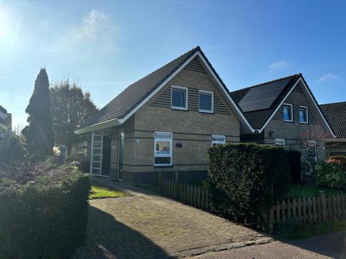 a house with a fence in front of it at Bungalow Ijsselmeer in Medemblik