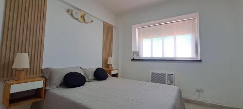a white bedroom with a bed and a window at Despertar Urbano in Corrientes