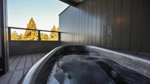 a bath tub in a room with a window at Kaze no Tani no Iori in Gamagori