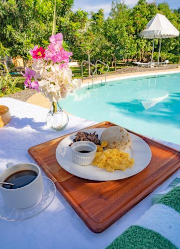 a plate of breakfast food on a table next to a pool at Ana-as Apartelle (GGL) in Panglao