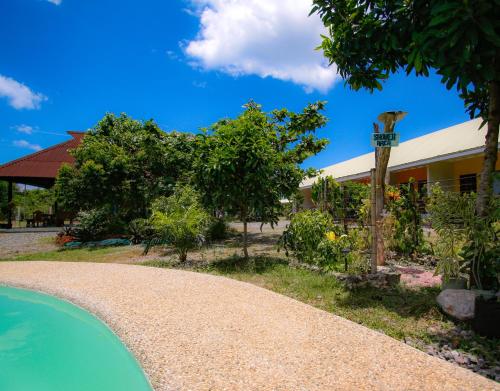 a house with a swimming pool next to a building at Ana-as Apartelle (GGL) in Panglao