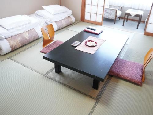 雫石町にある盛岡つなぎ温泉　旅染屋 山いち のテーブルとベッドのあるリビングルーム