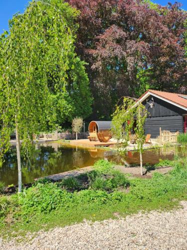 a house with a boat in the water next to a lake at Huize Koempoelan in Naarden