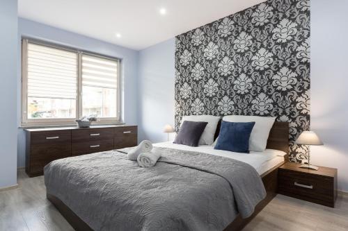 a bedroom with a large bed with a patterned wall at VIP Apartamenty Stara Polana 2 in Zakopane
