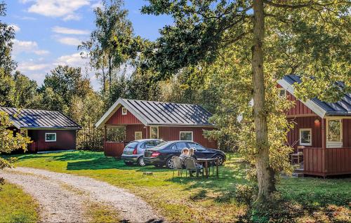 a couple of red buildings with cars parked in the yard at Juelsminde Campinghytte in Juelsminde