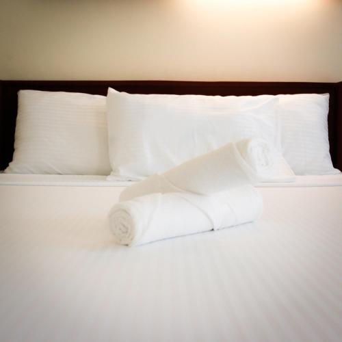 a pile of white towels sitting on a bed at Ana-as Apartelle (GGL) in Panglao