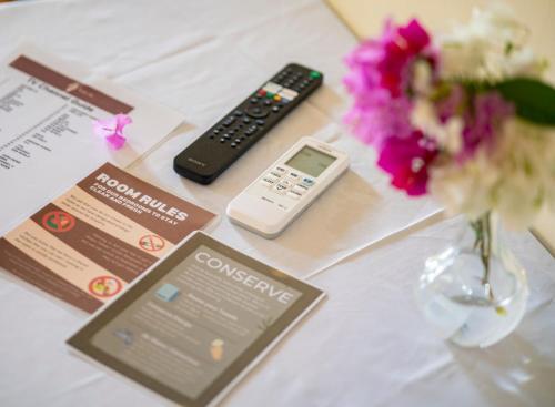 a table with a cell phone and a remote control at Ana-as Apartelle (GGL) in Panglao