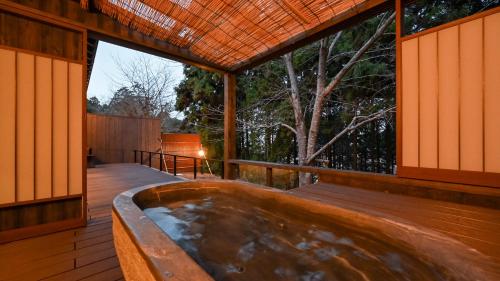 a hot tub on the deck of a house at Kaze no Tani no Iori in Gamagori