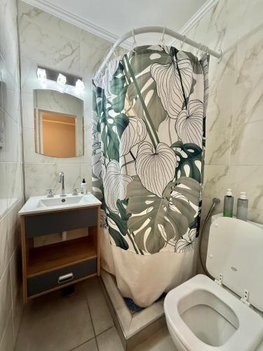 a bathroom with a shower curtain with a toilet and a sink at Blue Ocean in Mar del Plata