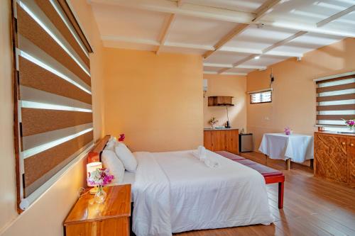 a bedroom with a white bed and a table at Ana-as Apartelle (GGL) in Panglao