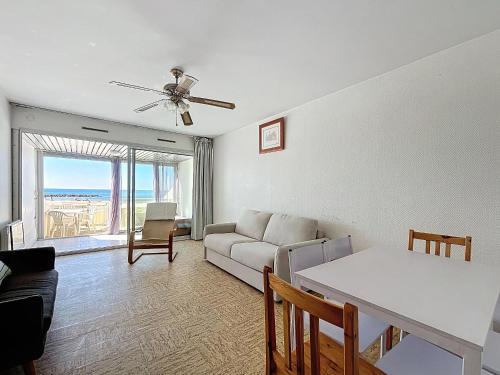 un salon avec un canapé et une table dans l'établissement Studio pour 4 avec terrasse et accès direct plage - Carnon, proche Montpellier - Wifi inclus - FR-1-715-51, à Mauguio