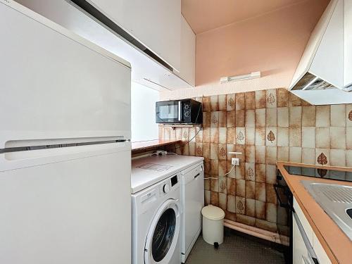 une cuisine avec un lave-linge et un micro-ondes dans l'établissement Studio pour 4 avec terrasse et accès direct plage - Carnon, proche Montpellier - Wifi inclus - FR-1-715-51, à Mauguio