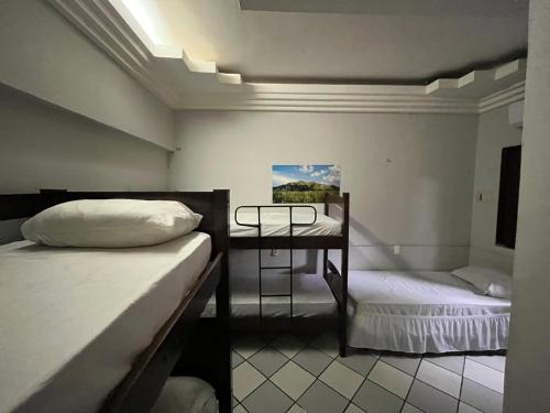 a room with two beds and a table in it at Casa Piauí Hostel in Teresina