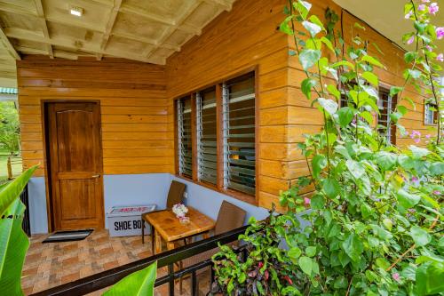 a porch of a wooden house with a table and chairs at Ana-as Apartelle (GGL) in Panglao