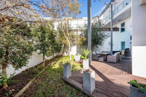 a backyard with a wooden deck with a couch at Beachfront Hampton in Melbourne