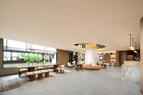 a lobby with chairs tables and a large window at Atour Hotel Shanghai Dapu Bridge ASE Center in Shanghai