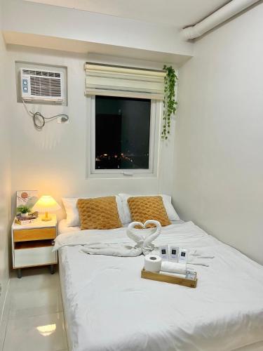 a bedroom with two beds and a window at Cozy 2BR Stay for 6pax in High-Floor, Wi-Fi & Family Games near IT Park Cebu- Unit Scarlett by GERRA in Mandaue City